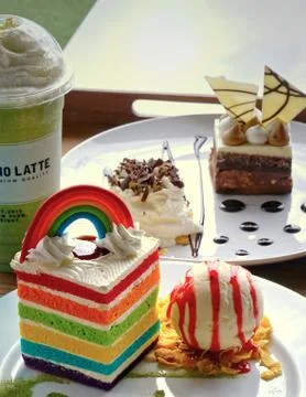 Piece of rectangular shape velvet rainbow cake with scoop of vanilla ice crea Stock Photos