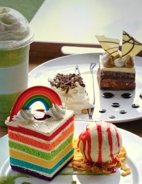 Piece of rectangular shape velvet rainbow cake with scoop of vanilla ice crea Stock Photos