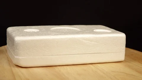 A piece of rectangular styrofoam lying horizontally rotates 360 degrees Stock Footage 120023993