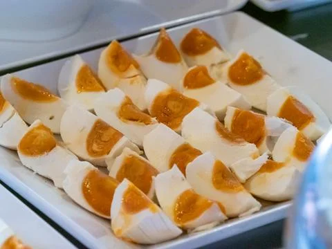 Piece of salted egg on squre plastic plate Foto stock