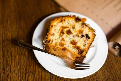 The piece of the sponge cake with nuts and dry fruit. The side photo. Stock Photos