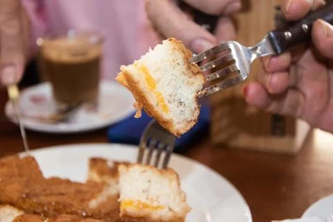 Piece of sponge cake punctured on a fork to eat it on the plate Stock Photos