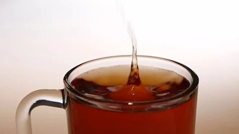 Piece of sugar falls into a cup tea. Close ups Stock Footage 73854141