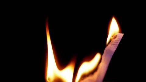 Piece Of Textured Material Burning With Bright Flames On Solid Black Background 库存影片 330301161