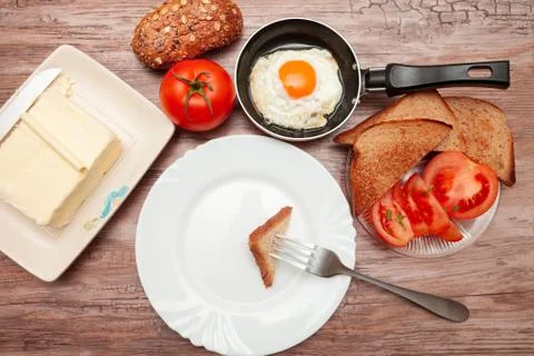 Piece of toast on a fork above empty plate Stock Photos