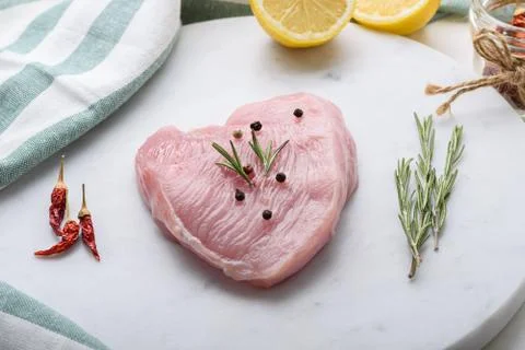 Piece of Turkey or chicken fillet on white marble Board with spices, lemon, r Stock Photos