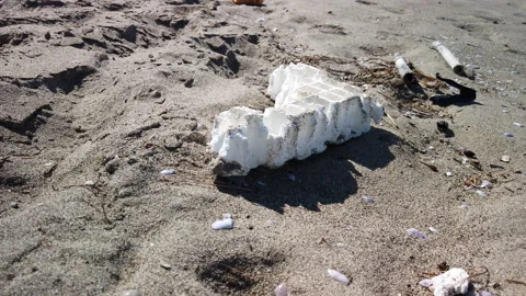 Piece of white styrofoam on the sand Video stock 186838996