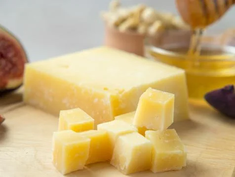 Pieces of aged cheese, nuts, figs and honey on a cutting board, Stock Photos