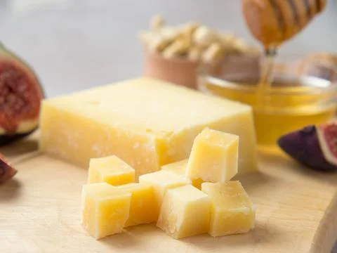 Pieces of aged cheese, nuts, figs and honey on a cutting board, Foto stock