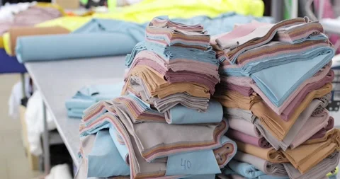Pieces and rolls of fabric lie on the table. Blurred background. Stock Footage 157356853