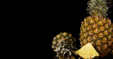 Pieces and a whole pineapple slowly rotate. Stock Footage 129802462