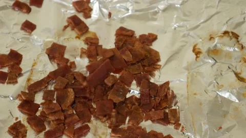 Pieces of Bacon Raining Down on Aluminum Foil Stock Footage 172260110