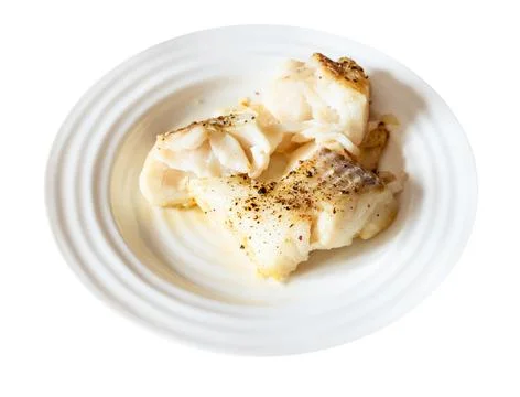 Pieces of baked and peppered cod fish cut out Stock Photos