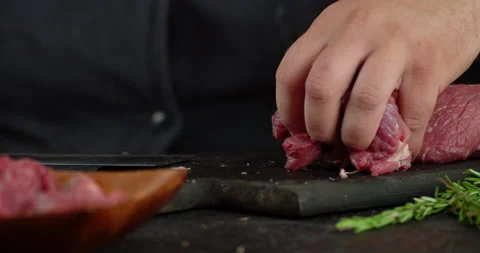 Pieces of beef are removed from the cutting board to a plate. Stock Footage 139150403