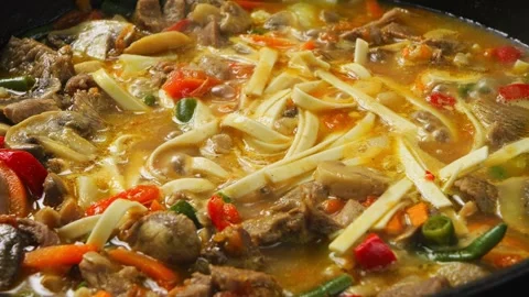 Pieces of beef in a frying pan with vegetables in a sauce with wok udon ste.. Stock Footage 256329324