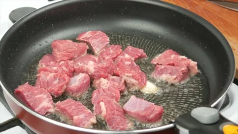 Pieces of beef meat fried in a pan, close-up, wooden spoon - healthy diet foo Stock Footage 133714981