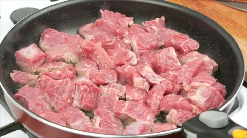 Pieces of beef meat fried in a pan, close-up, wooden spoon - healthy diet foo Stock Footage 133714992
