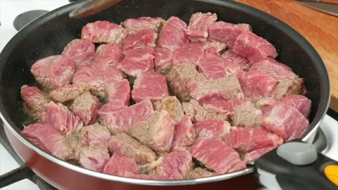 Pieces of beef meat fried in a pan, close-up, wooden spoon - healthy diet foo Stock Footage 133714994