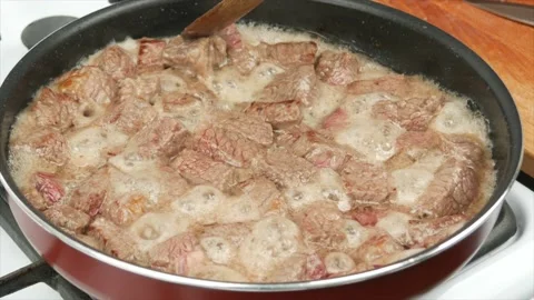 Pieces of beef meat fried in a pan, close-up, wooden spoon - healthy diet foo 動画素材 133715007
