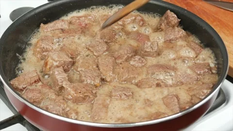 Pieces of beef meat fried in a pan, close-up, wooden spoon - healthy diet foo Stock Footage 133715016