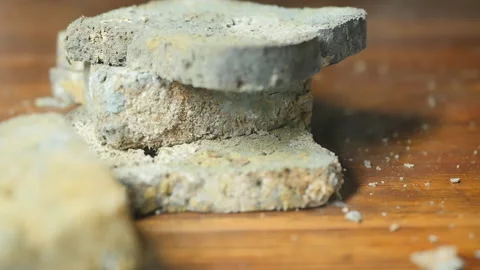 Pieces of black bread with mold fall on the wooden table in slow motion Stock Footage 164604119