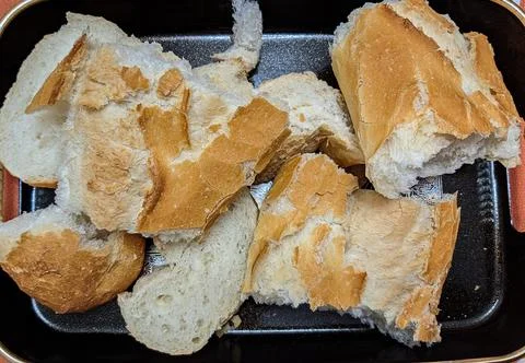 Pieces of bread broken by hand Stock Photos