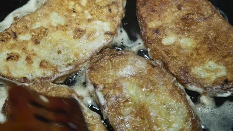Pieces of bread with a crust soaked in eggs fry in a frying pan 库存影片 225073925