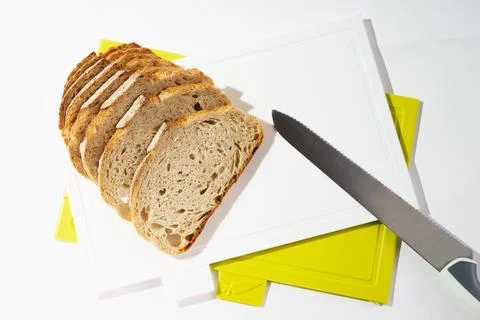 Pieces of bread on a cutting board top view on white clean plastic cutting board Stock Photos