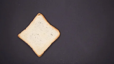 Pieces of bread fall on a black table. View from above. Toast bread Stock Footage 120452793