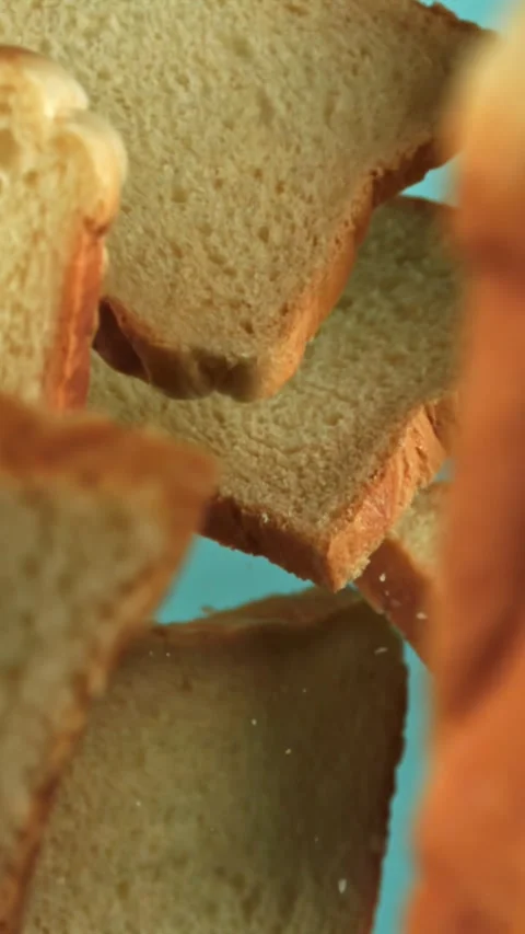 Pieces of bread fly up and fall on a blue background. Filmed on a high-speed Stock Footage 335380441