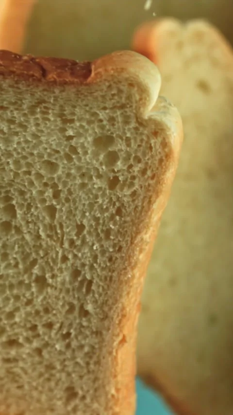 Pieces of bread fly up and fall on a blue background. Filmed on a high-speed Stock Footage 335385073