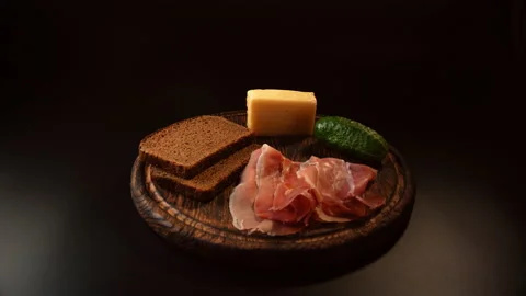 Pieces of bread, jamon, cucumber, cheese, laying out on a dish of beautiful food Stock Footage 148625409