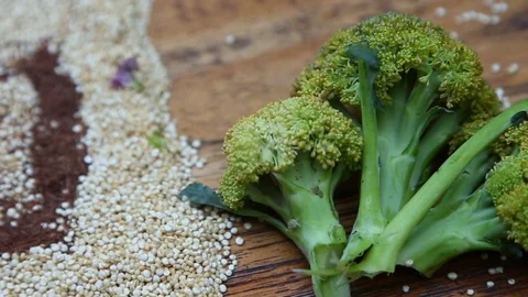 Pieces of broccoli on the table with raw quinoa Stock Footage 90087568