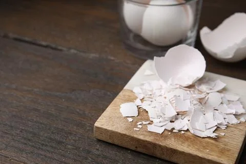 Pieces of broken eggshells on wooden table, closeup. Space for text Foto stock