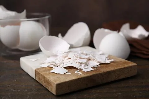 Pieces of broken eggshells on wooden table, closeup Foto stock