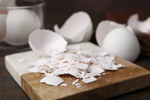 Pieces of broken eggshells on wooden table, closeup Foto stock