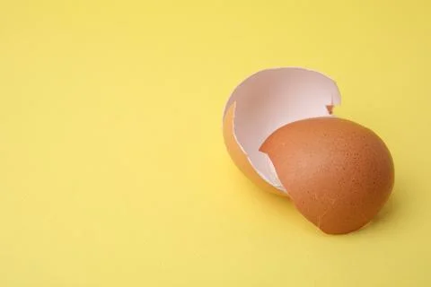 Pieces of broken eggshells on yellow background, closeup. Space for text 스톡 사진