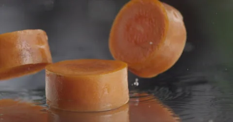 Pieces of carrot falls on a mirror surface Stock Footage 197042282