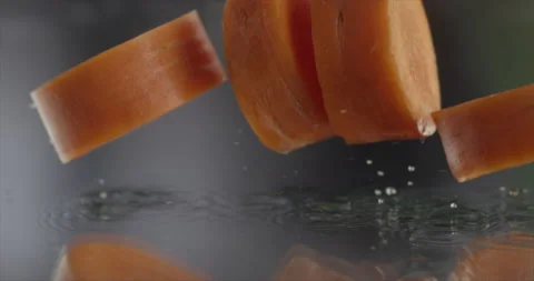 Pieces of carrot falls on a mirror surface with water Stock Footage 198146969