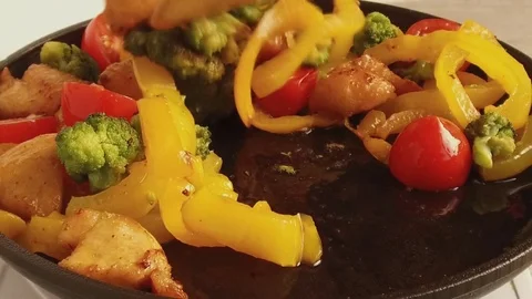 Pieces of chicken fillets fall into a frying pan with vegetables Stock Footage 79459234