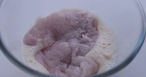 Pieces of chicken meat roll in raw eggs Stock Footage 125613855