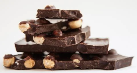 Pieces of chocolate with hazelnuts Stock Photos