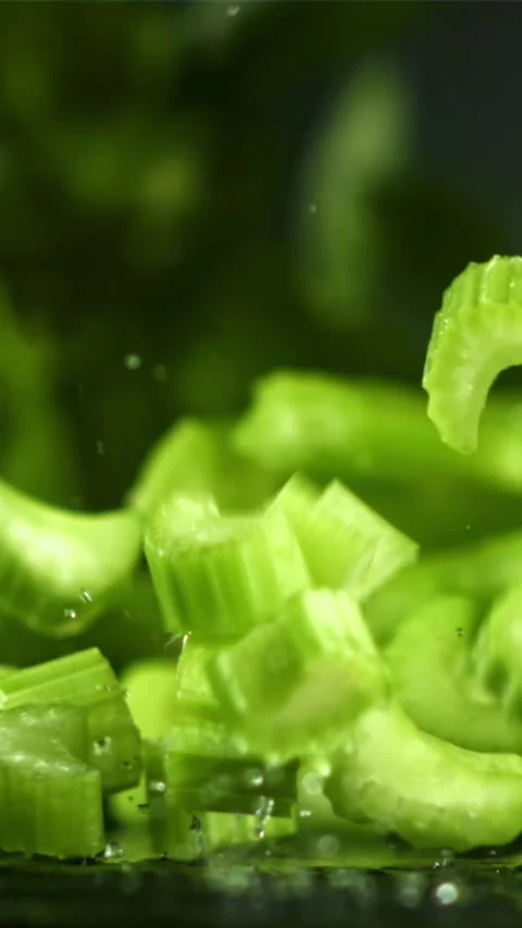 Pieces of chopped celery fall on the table. Filmed on a high-speed camera at Stock Footage 335320910