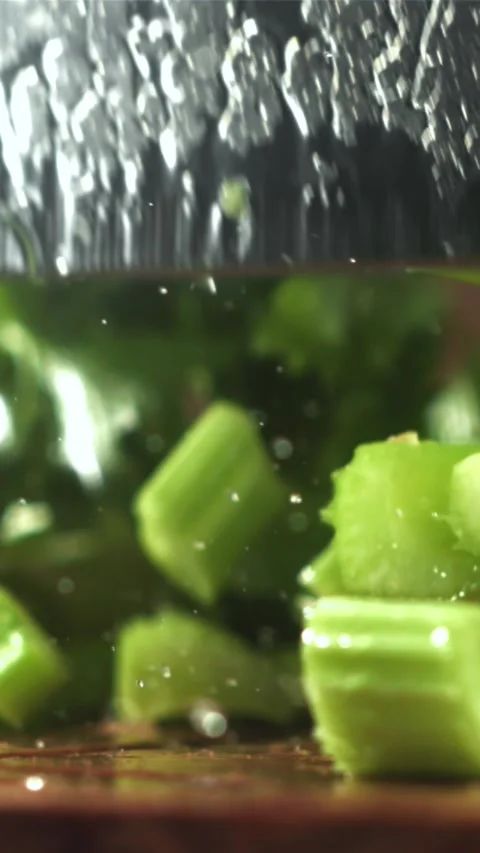 Pieces of chopped celery fall on the table. Filmed on a high-speed camera at Stock Footage 335322436