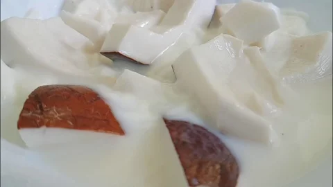 Pieces of coconut fall into milk slow-motion Video stock 87876853