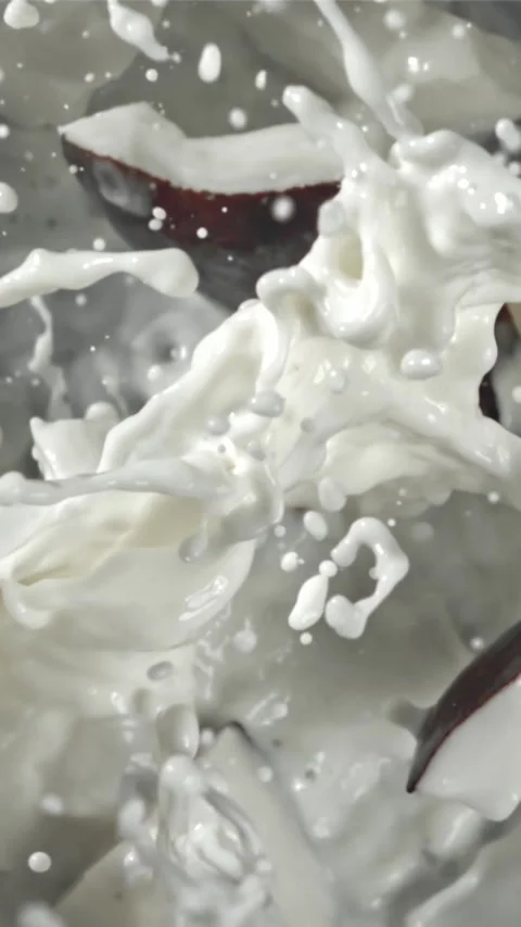 Pieces of coconut fall into the milk with splashes. Filmed on a high-speed 動画素材 335359329
