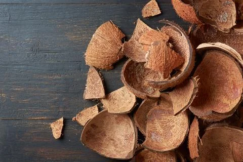 Pieces of coconut fruit shell on table top Stock Photos