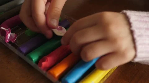Pieces of colored plasticine rolls in a plastic container, taking from table Stock Footage 138863915