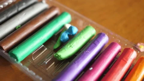 Pieces of colored plasticine rolls in a plastic container Stock Footage 138863974