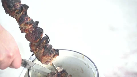 Pieces of cooked barbecue are put in a pan before serving 4K Stock Footage 128794810